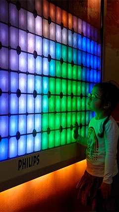Un copil lângă Imagination Light Canvas de la Iluminat Philips