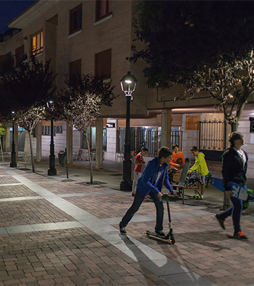 Oameni mergând pe străzile din Palencia noaptea sub lumina proiectată de sistemele de iluminat de la Philips