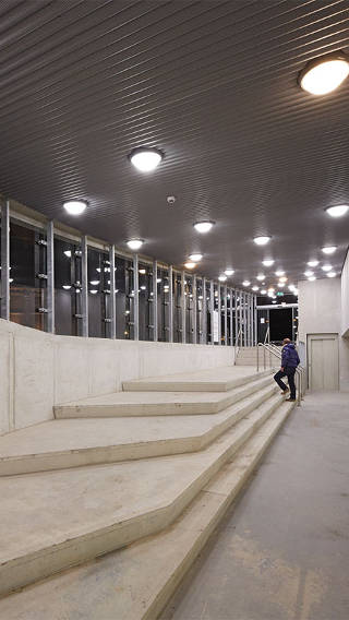  Bărbat urcând scările în parcarea Eiteren iluminată cu sisteme de iluminat de la Philips 
