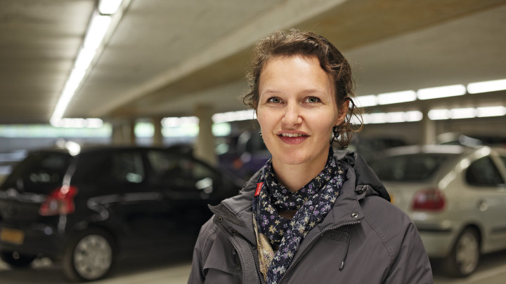  Femei zâmbind în faţa automobilelor în parcarea Eiteren iluminată cu sisteme de iluminat de la Philips 