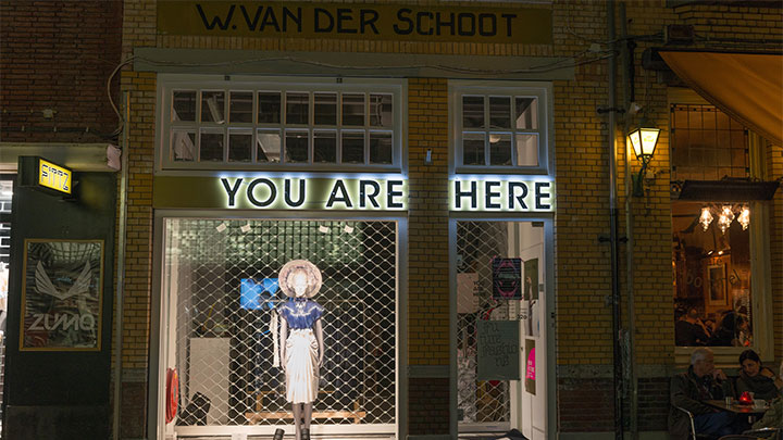 Vitrină iluminată a magazinului de modă you are here