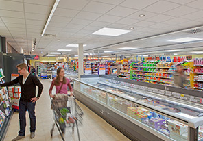 Un cuplu pe un culoar dintr-un supermarket iluminat cu lămpi economice de la Philips 