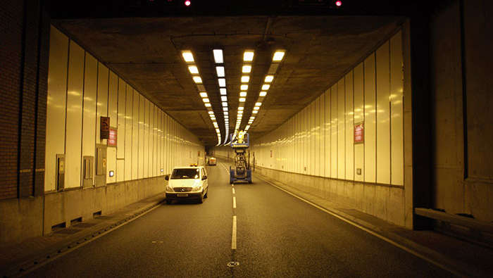 Muncitori în interiorul unui tunel efectuând lucrări de întreţinere a sistemului de iluminat