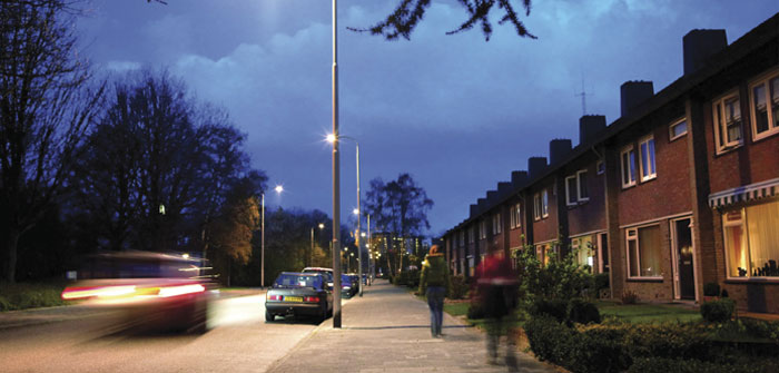Automobile pe o stradă iluminată eficient cu lumina albă de la Philips