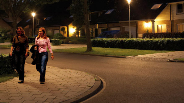 Două femei mergând pe o stradă iluminată cu lumină albă marca Philips