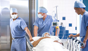 Medici transportând un pacient sub lumina proiectată de sistemele de iluminat pentru spitale de la Philips