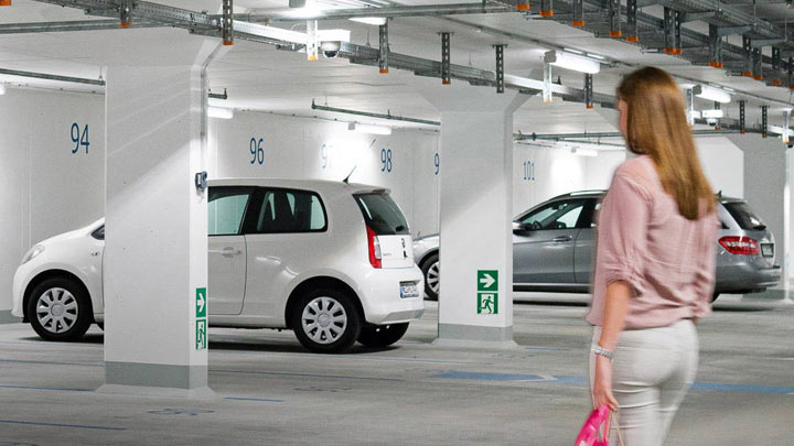 O femeie se îndreaptă către automobilul său într-o parcare subterană bine iluminată 