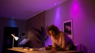 Cu luminile LED inteligente Philips Hue poți crea o ambianță vibrantă cu nuanțe de roz și violet în living, alegând astfel un iluminat personalizat pentru nopți de film și relaxare în confortul casei tale.